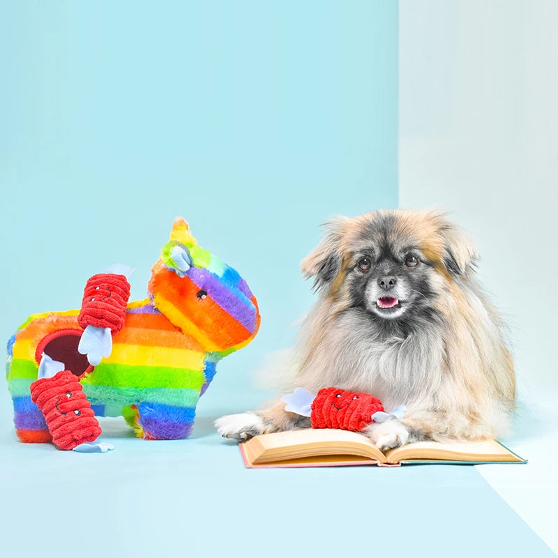Small fluffy dog beside a Zippy Paws Burrow rainbow pinata plush dog toy