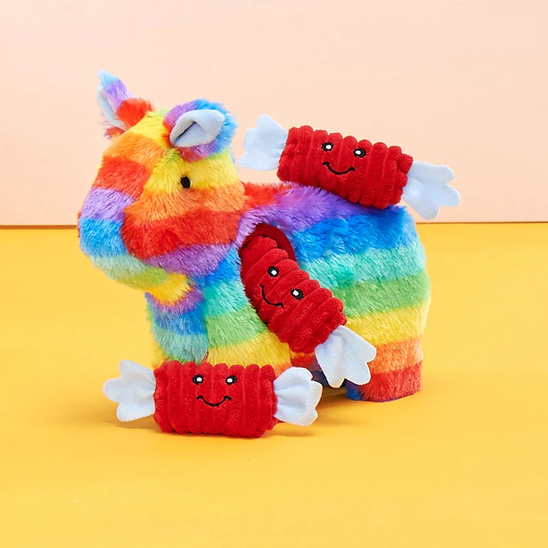 Zippy Paws Burrow rainbow pinata dog toy styled on a bright party backdrop