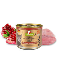 GranataPet Symphonie No. 9 Pheasant & Rabbit 200g tin, front of pack, beside raw game meat and a halved pomegranate