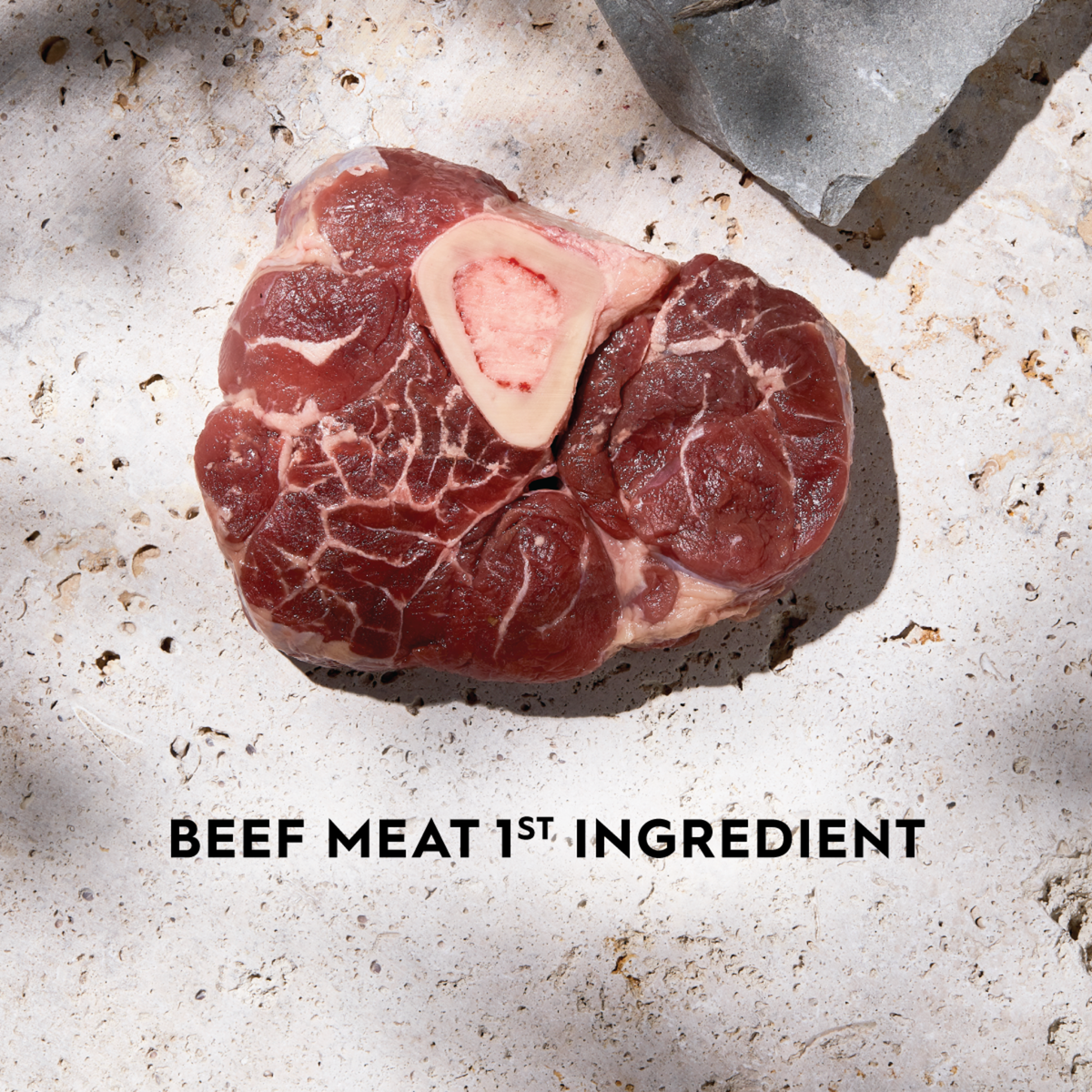 Raw beef steak on a stone surface with the caption beef meat first ingredient