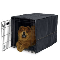 A brown dog lying in a MidWest wire crate fitted with the black fabric crate cover