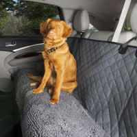 Grey quilted Dirty Dog car seat cover with a dog sitting on the back seat