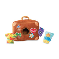 Fringe Studio Pack Your Bags burrow dog toy, plush suitcase with holiday-themed mini toys beside it.