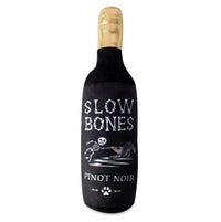 Fringe Studio Slow Bones Pinot Noir plush dog toy, black wine bottle with a skeleton dog label.