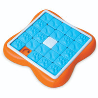 Nina Ottosson Challenge Slider Level 3 dog puzzle, blue textured tile set in an orange frame, from above