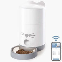 Catit PIXI Smart cat feeder with a bowl of kibble and a phone showing the PIXI app
