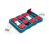 Nina Ottosson Dog Brick Level 2 puzzle, teal board with red sliding bricks and white bone pegs