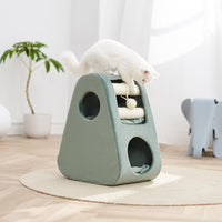 A white cat standing on the Petsbelle Dune cat house, a sage green wedge with two round openings