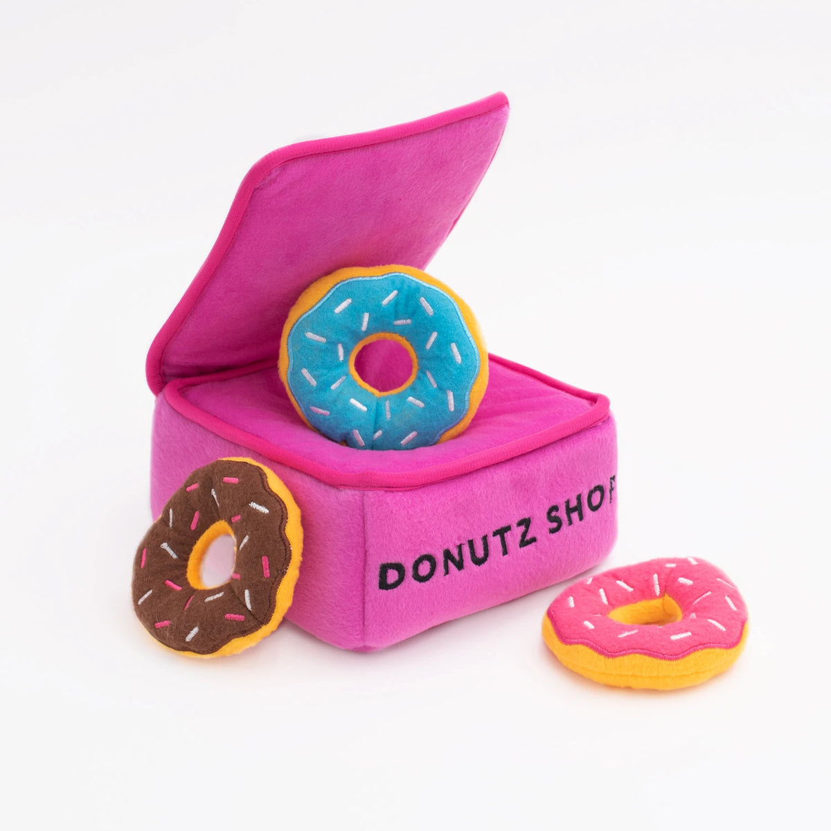 Zippy Paws Donutz Burrow pink box dog toy with a blue plush donut tucked inside