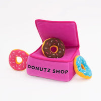 Zippy Paws Donutz Burrow plush dog toy: a pink Donutz Shop box with squeaky donuts