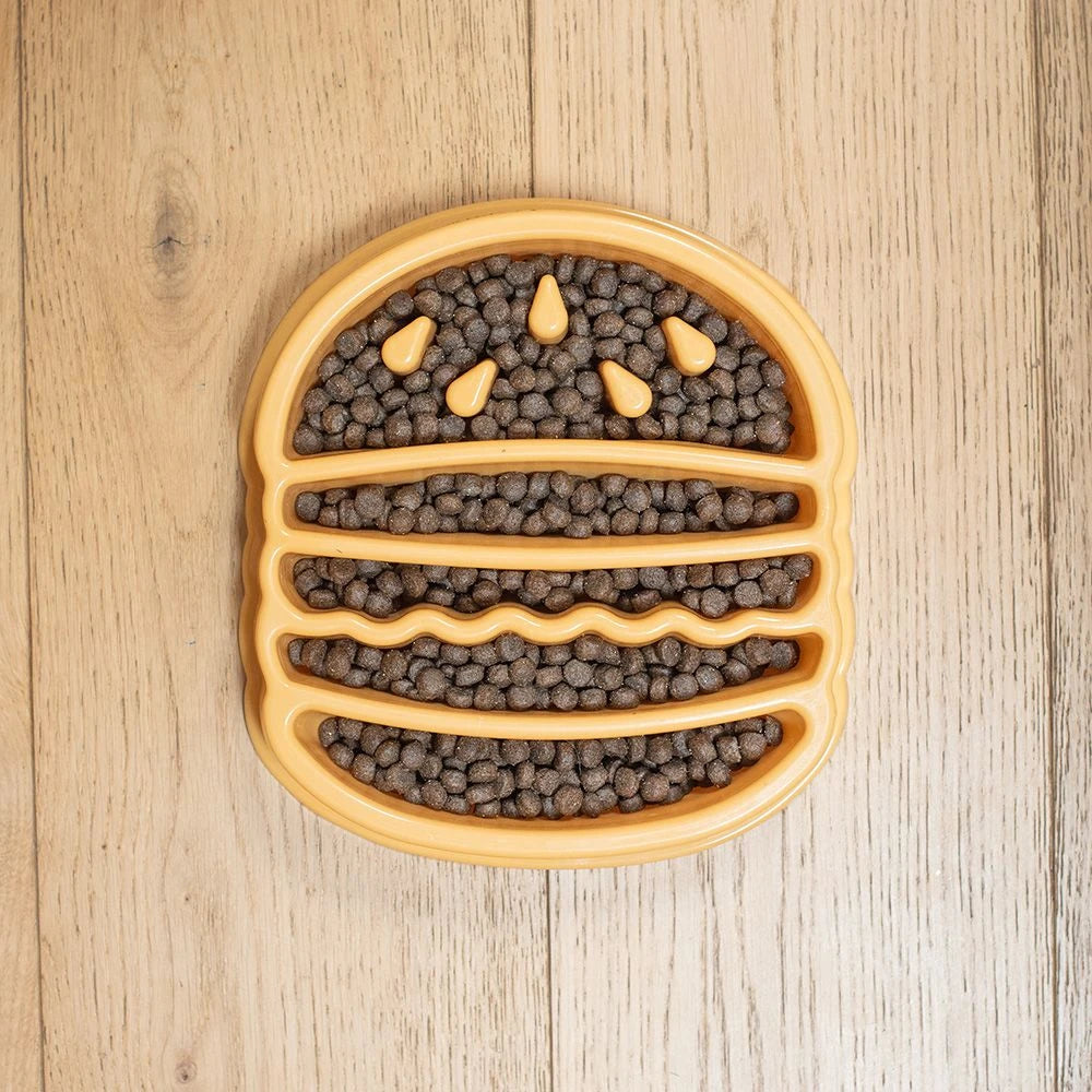 Zippy Paws hamburger-shaped slow feeder bowl filled with kibble on floorboards