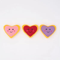 Three Zippy Paws Miniz heart-shaped plush cookie dog toys in pink, red and purple