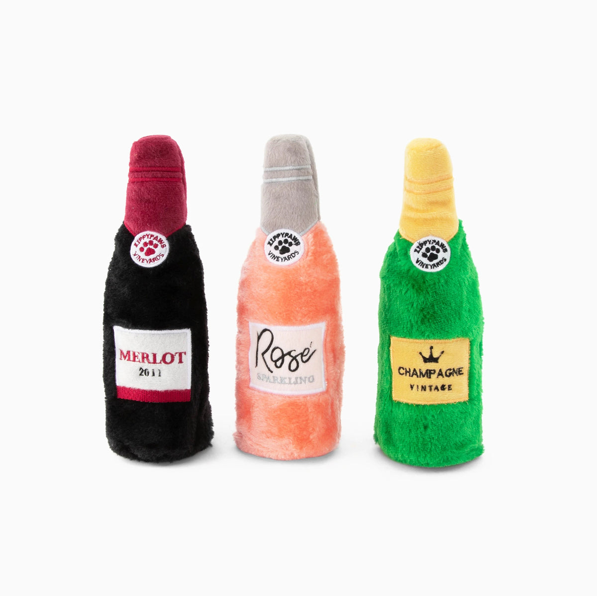 Three Zippy Paws Happy Hour Crusherz plush wine bottle dog toys shown out of their box
