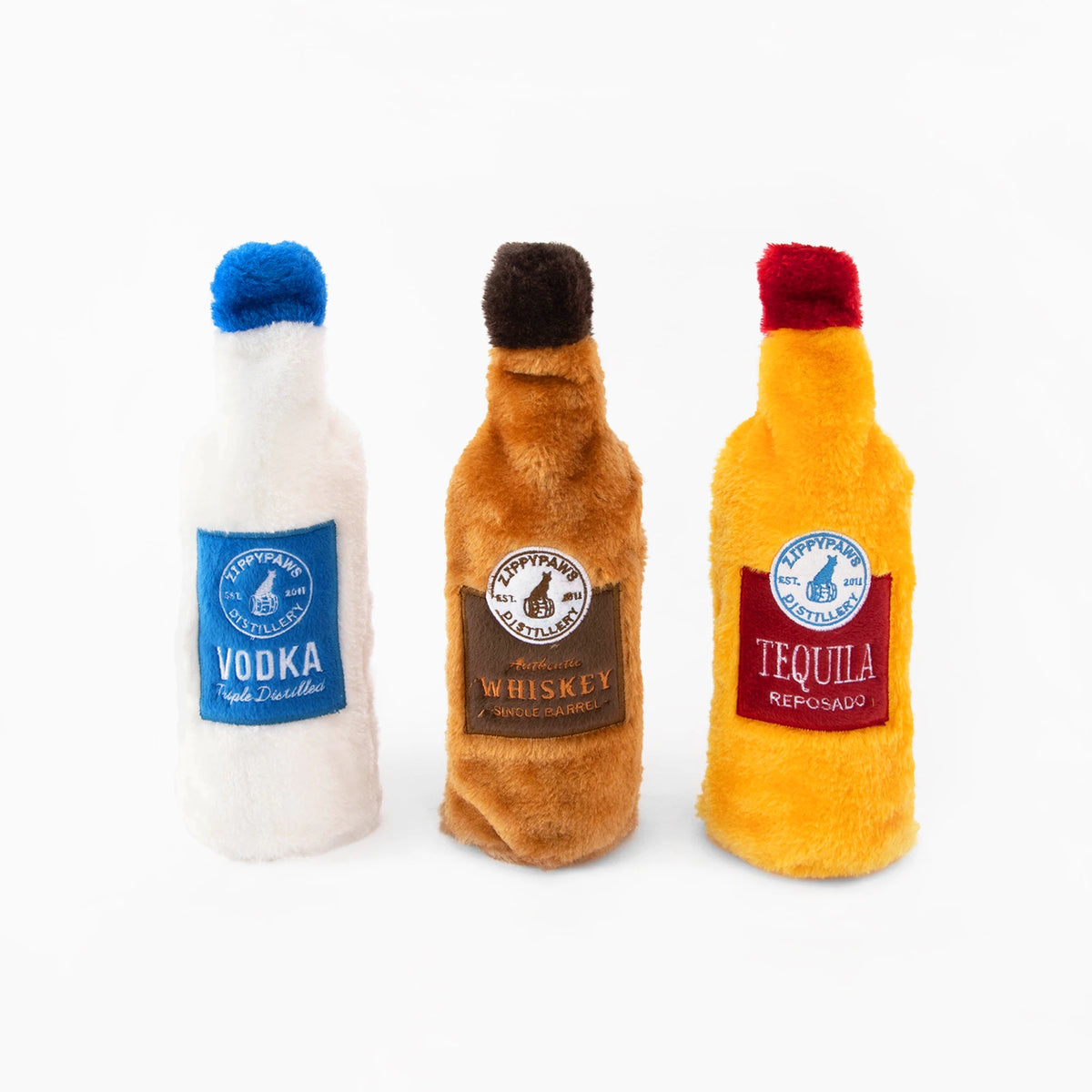 Three Zippy Paws Happy Hour Crusherz plush spirits bottle dog toys shown out of their box